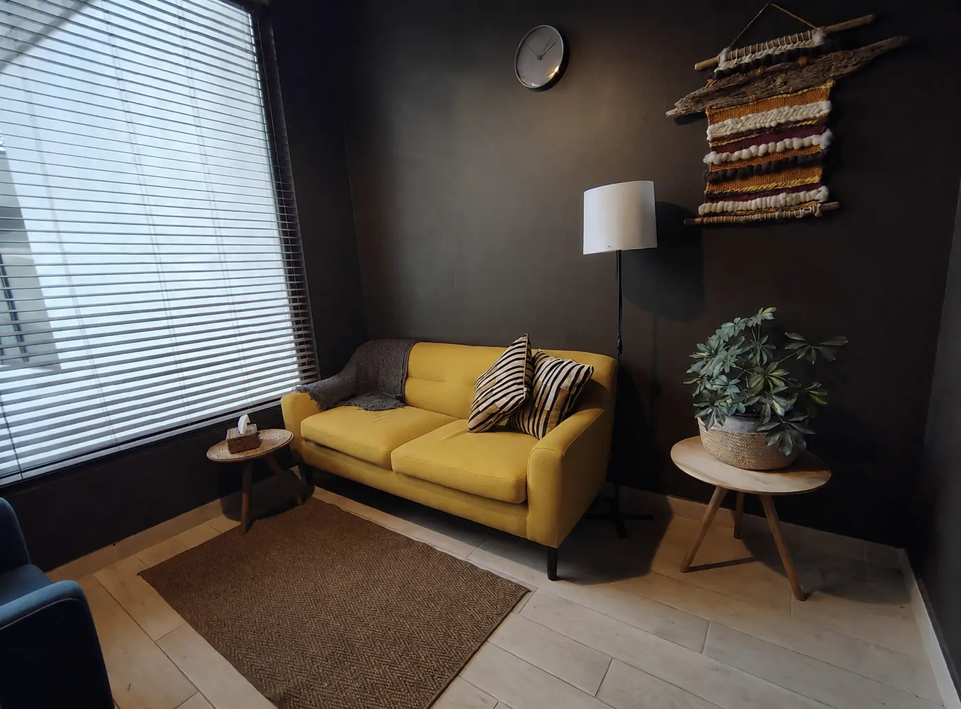 Sala de atención cálida con sofá amarillo y luz natural